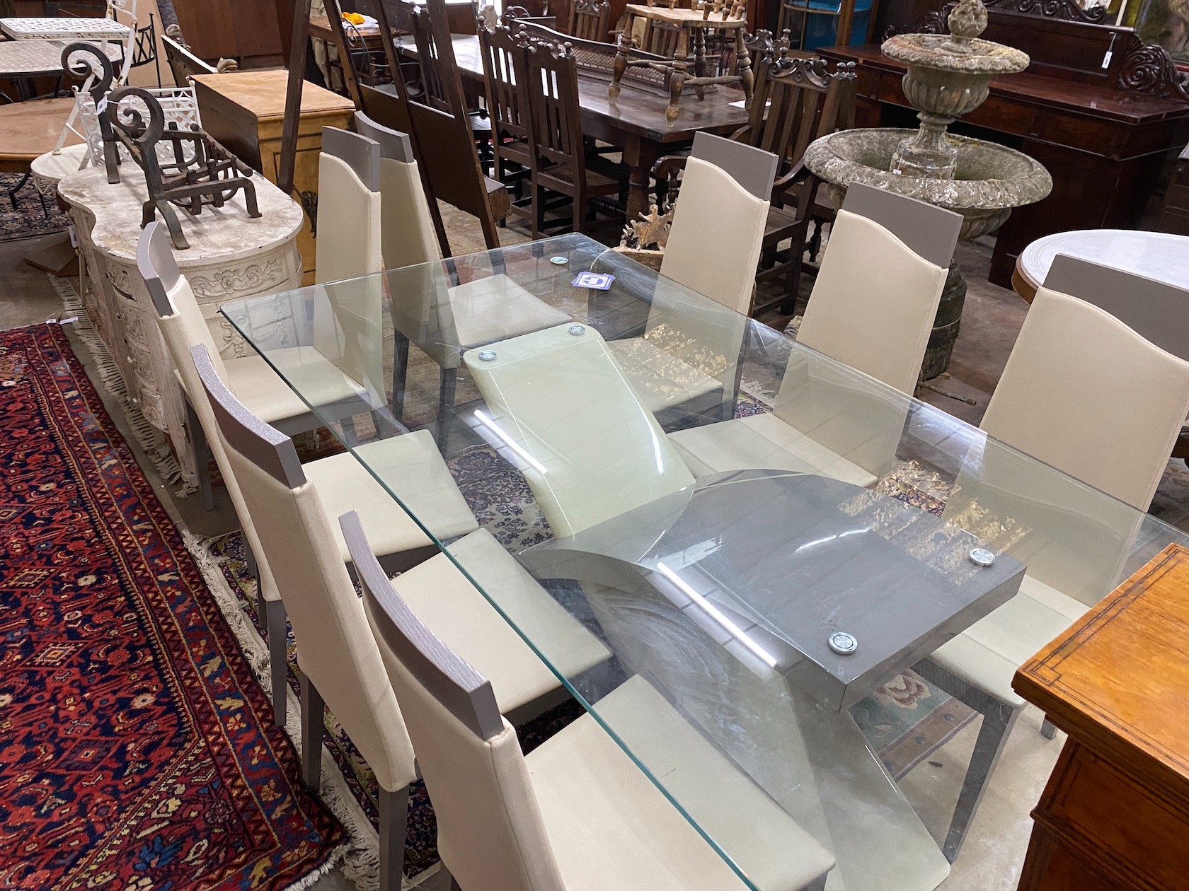 A contemporary rectangular glass topped dining table, length 199cm, depth 107cm, height 78cm and a set of eight cream leather high back chairs